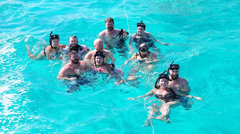 Guests snorkeling near a coral reef