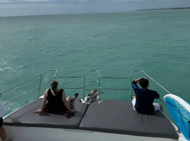 Pasajeros en la proa de un barco en mar tranquilo