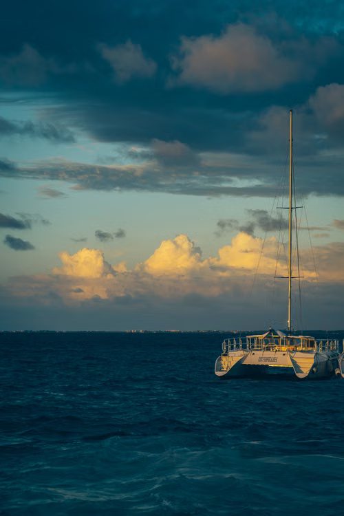 Un velero bajo las nubes al anochecer