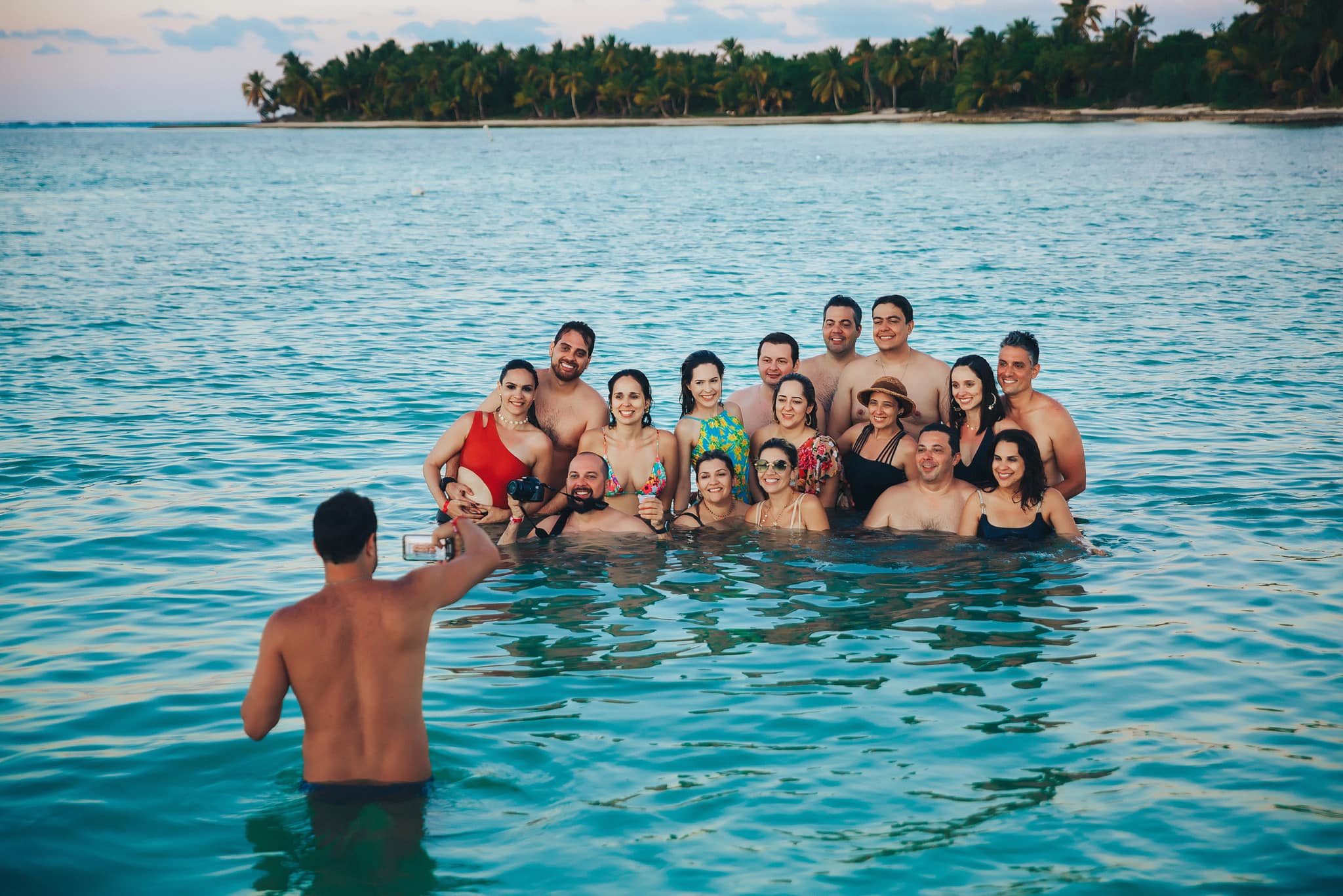 Un grupo disfrutando juntos en el agua junto a la costa