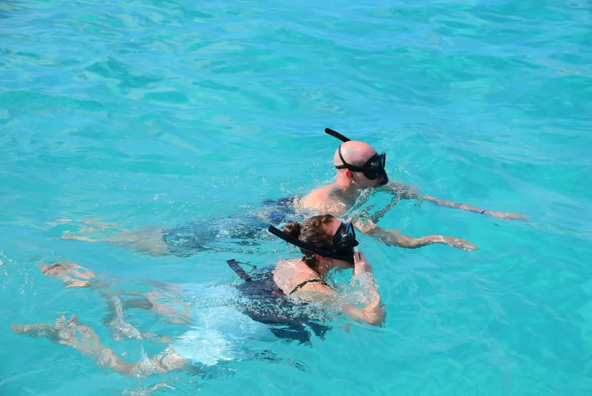 Two guests snorkeling in turquoise water